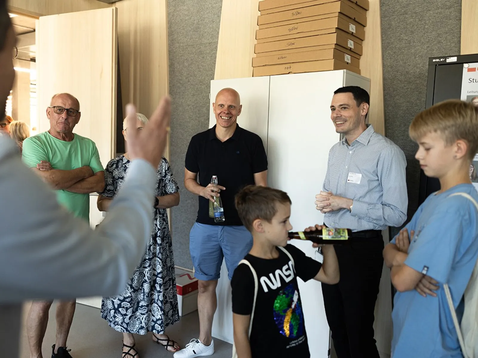 Gruppe von Menschen bei einer Führung im neuen Standort der Universität Liechtenstein, Ebaholz, während des Tags der offenen Tür. Ein Mann spricht zu den Besuchern, die aufmerksam zuhören.