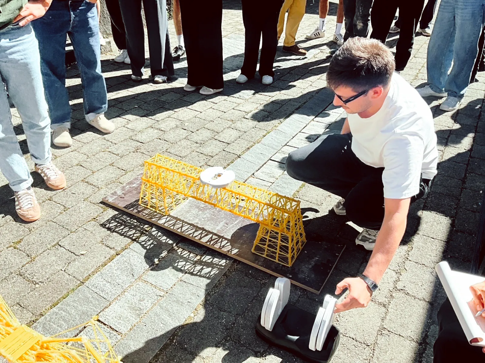 Student baut eine Brücke aus Spaghettinudeln