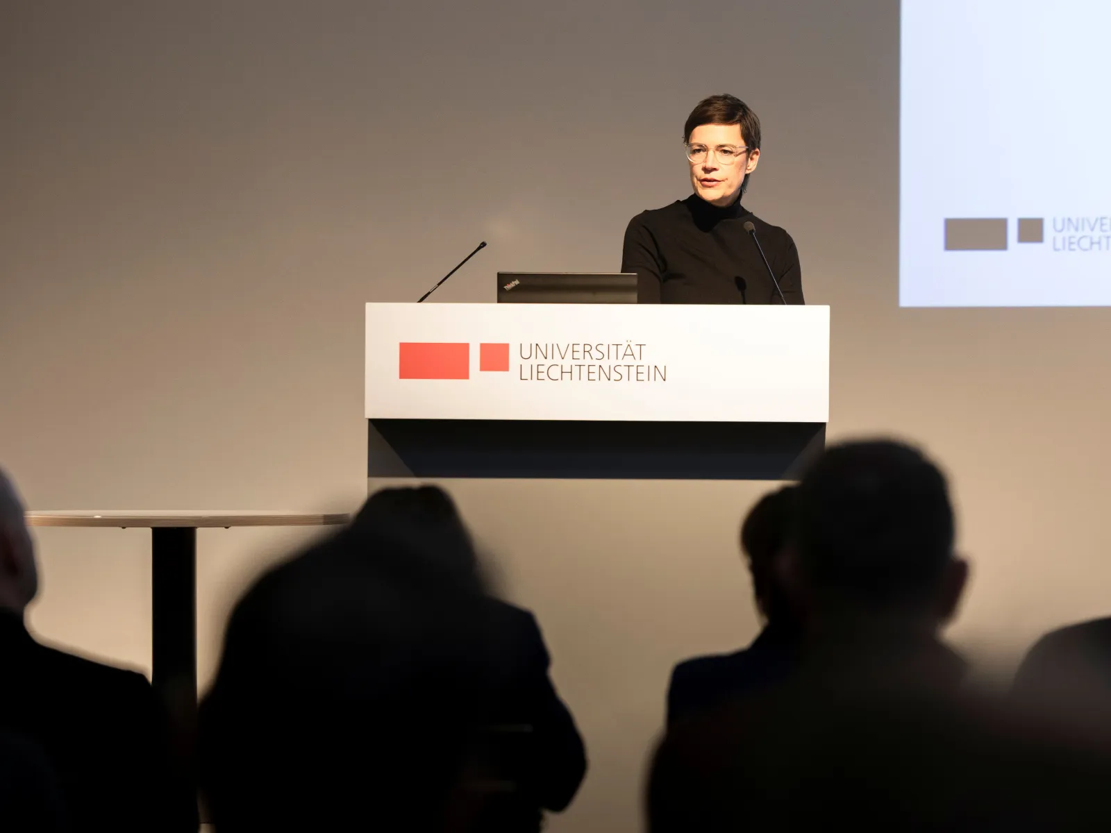 Eine Person präsentiert an einem Vortragspult