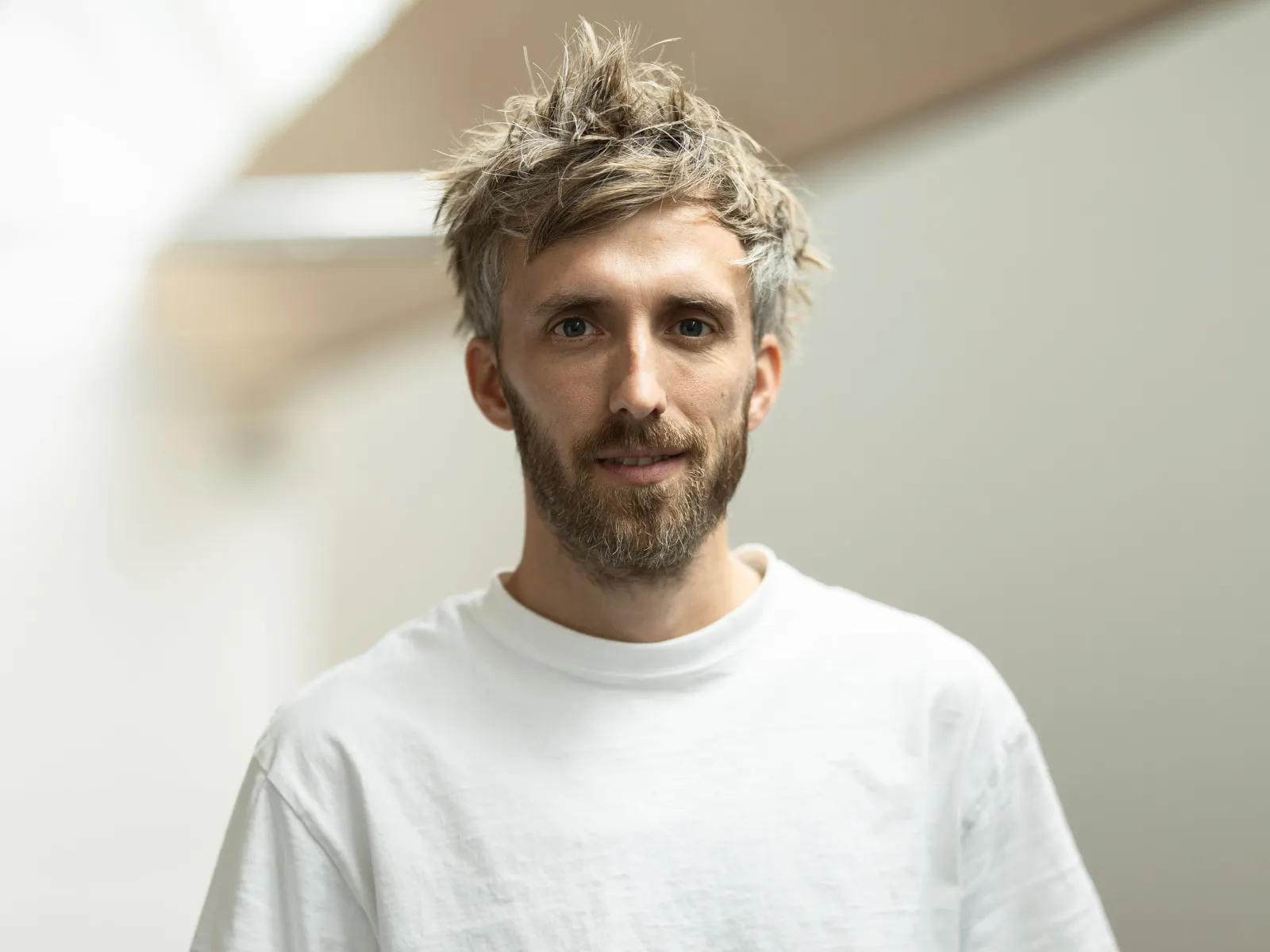 Foto eines jungen Mannes mit weissem T-Shirt und Bart