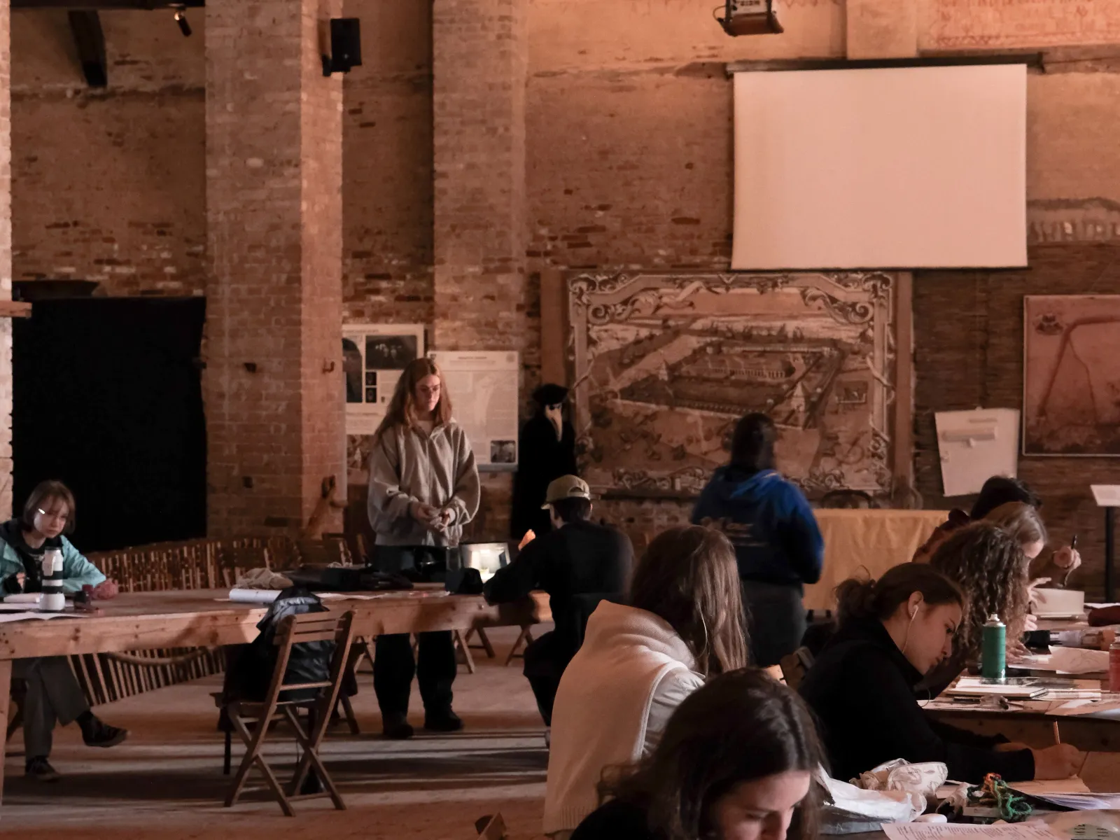 Mehrere arbeitende Studierende in einer alten Halle 