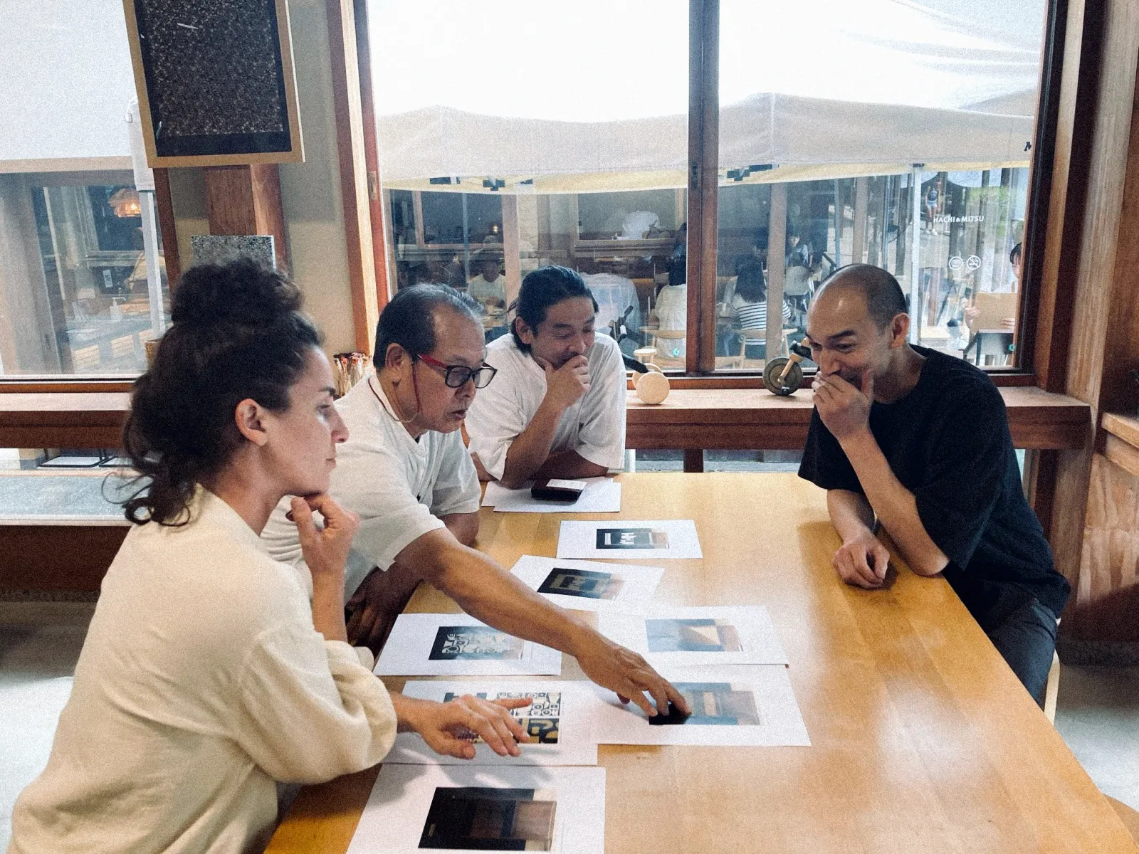 Gruppe analysiert Entwürfe und Bilder bei gemeinsamer Projektarbeit im Arbeitsraum