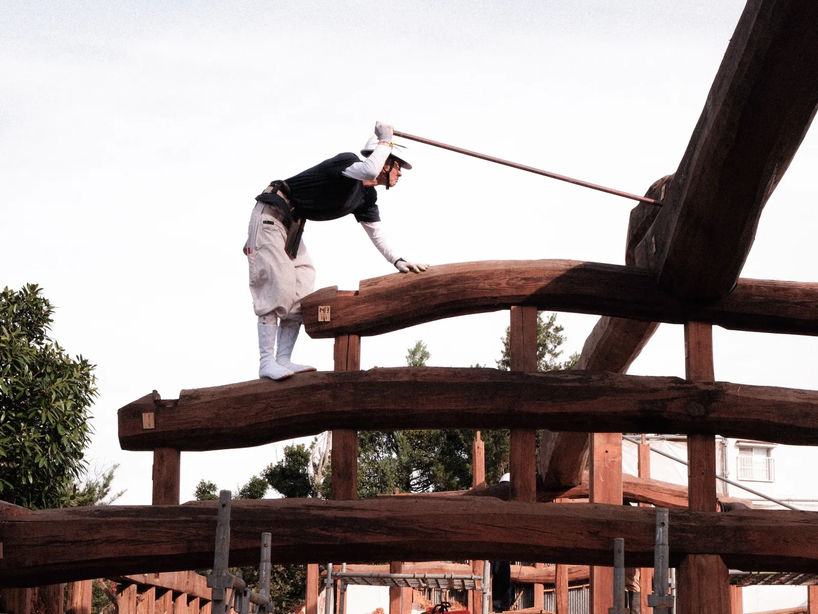 Restaurationsarbeit an historischer Holzbalkenkonstruktion mit Werkzeug und traditioneller Technik