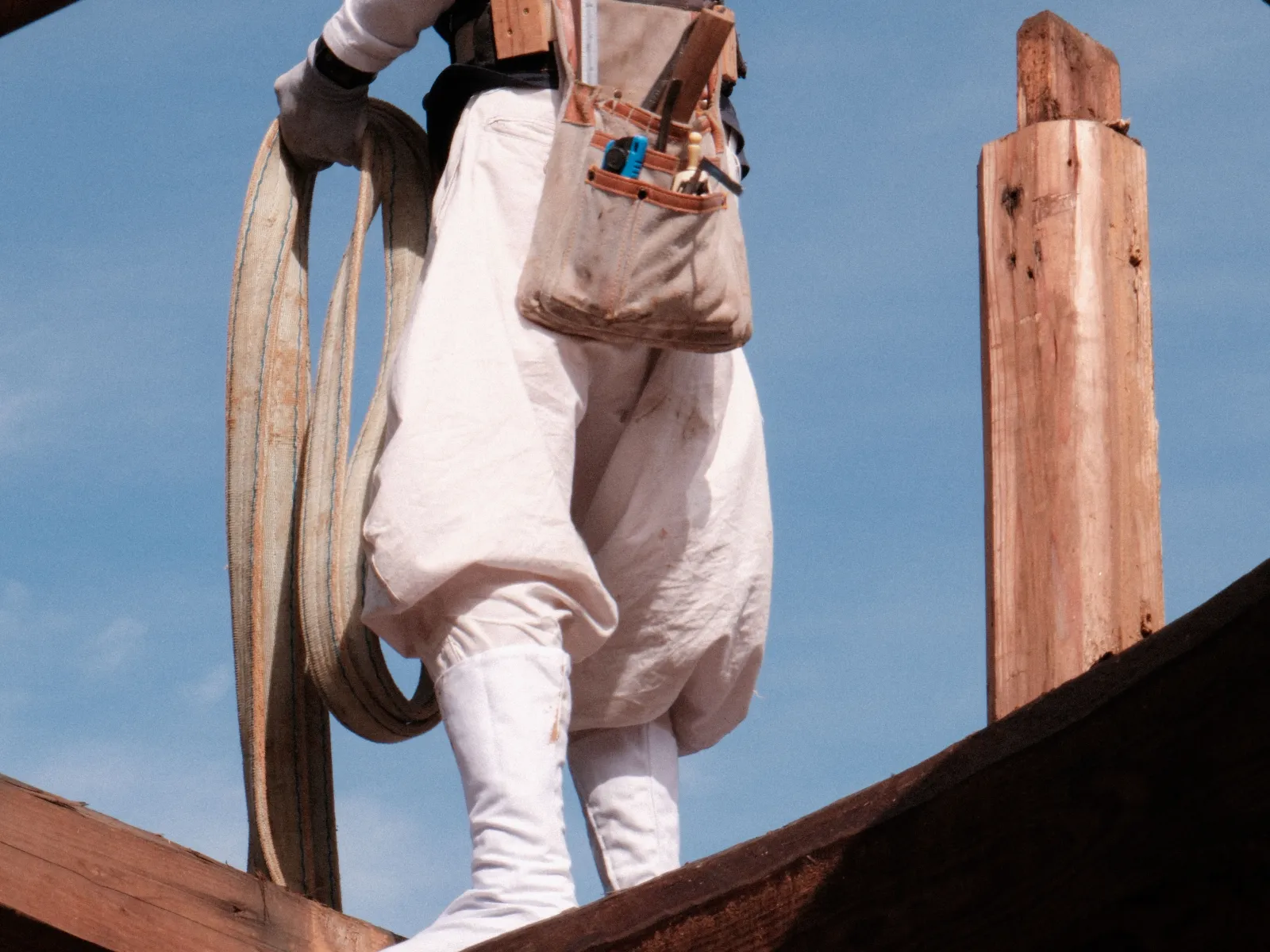 Handwerkerin arbeitet an traditioneller Holzkonstruktion während Restaurationsprojekt