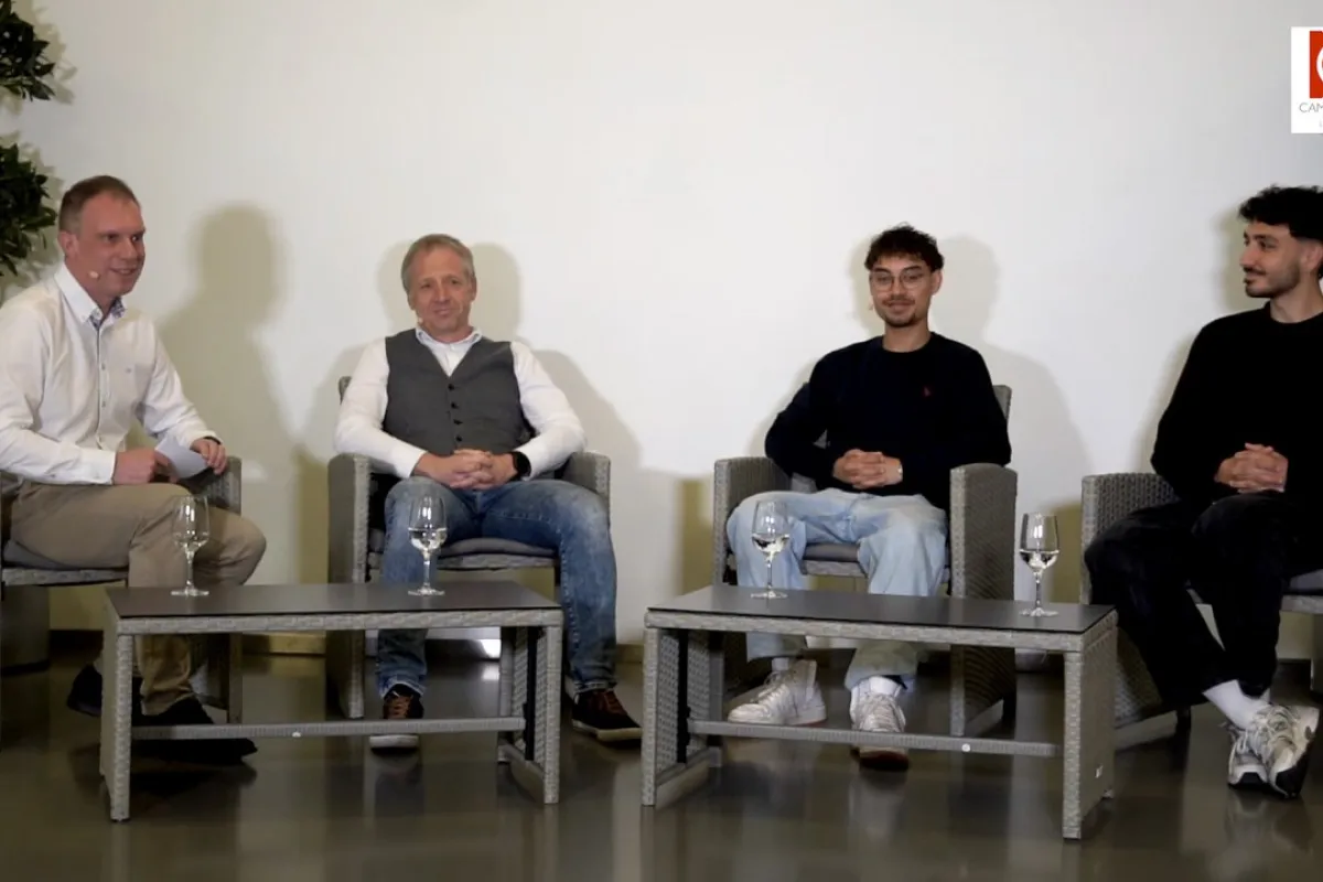 Vier Männer sitzen in einer Gesprächsrunde auf grauen Sesseln. Vor ihnen stehen zwei niedrige Tische mit Wassergläsern. Im Hintergrund sind Pflanzen zu sehen. Oben rechts befindet sich das Logo des Campus Radio der Universität Liechtenstein.