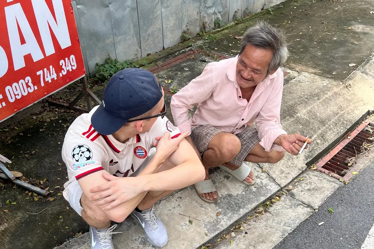 Der Autor zusammen mit einem Vietnamesen am Strassenrand sitzend