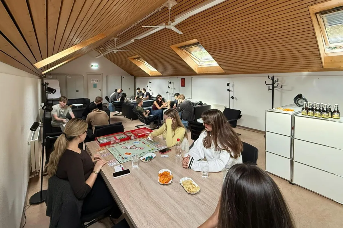 Mehrere Studierende sitzen in einem Raum und spielen