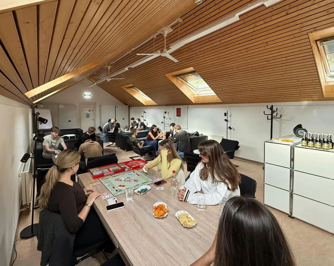 Mehrere Studierende sitzen in einem Raum und spielen