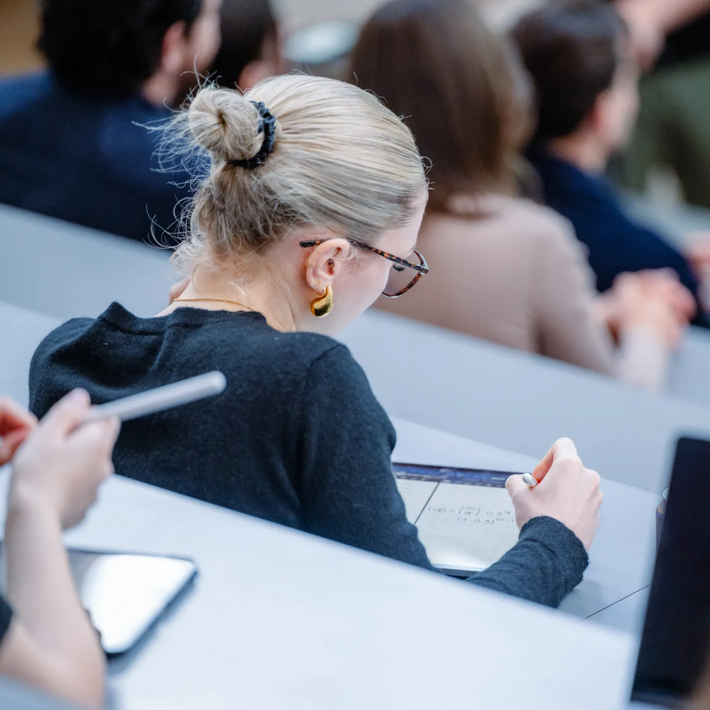 Eine Studentin macht sich digitale Notizen auf einem Tablet während einer Vorlesung an der Universität Liechtenstein.