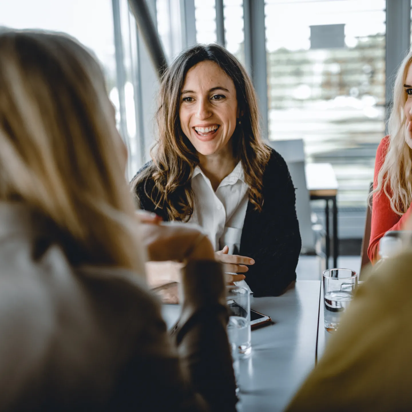 Gruppe junger Frauen im Gespräch in der Cafeteria der Universität Liechtenstein – entspannter Austausch und lebendige Campusgemeinschaft.