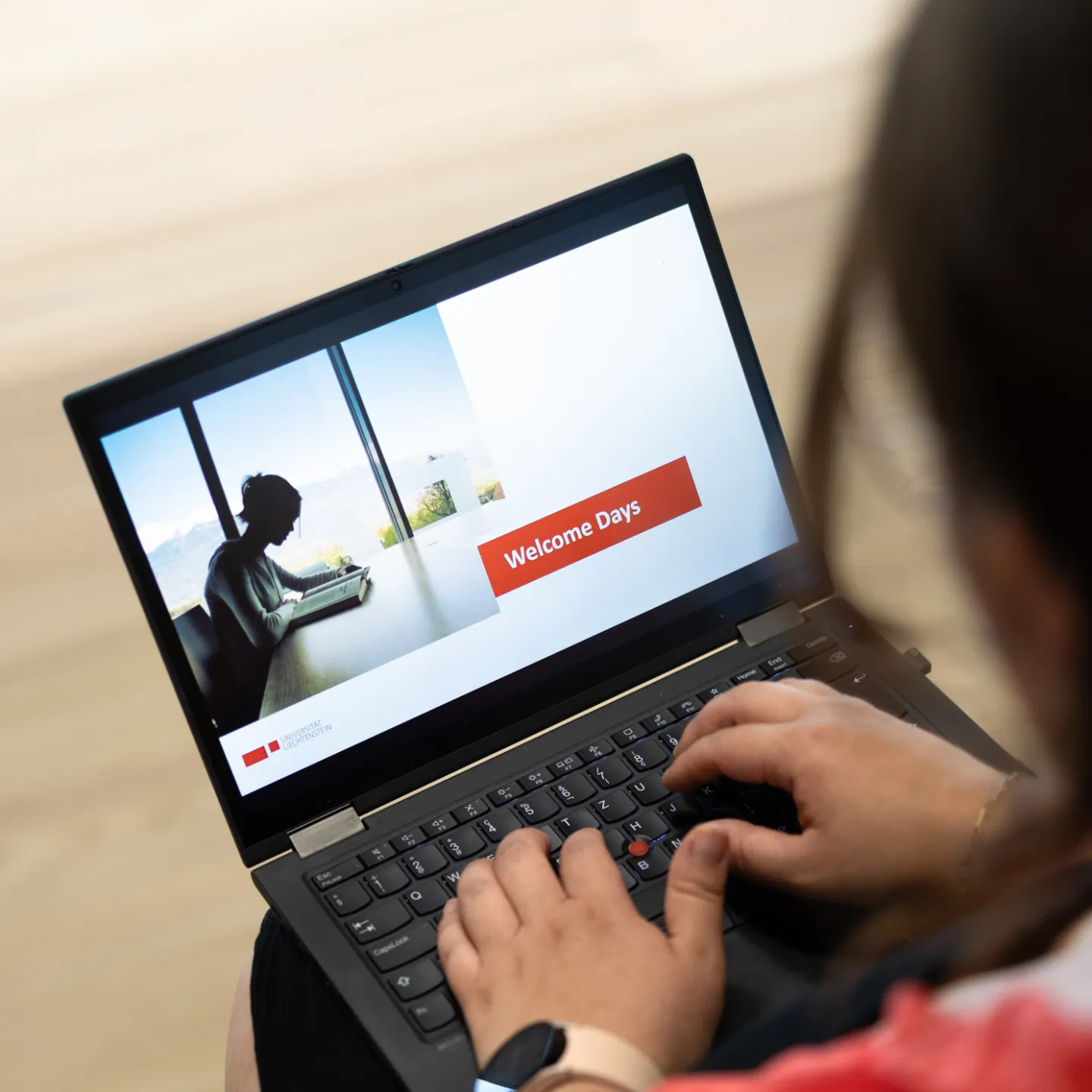 Die Person nimmt mit dem Laptop an der Welcome der Universität Liechtenstein teil.