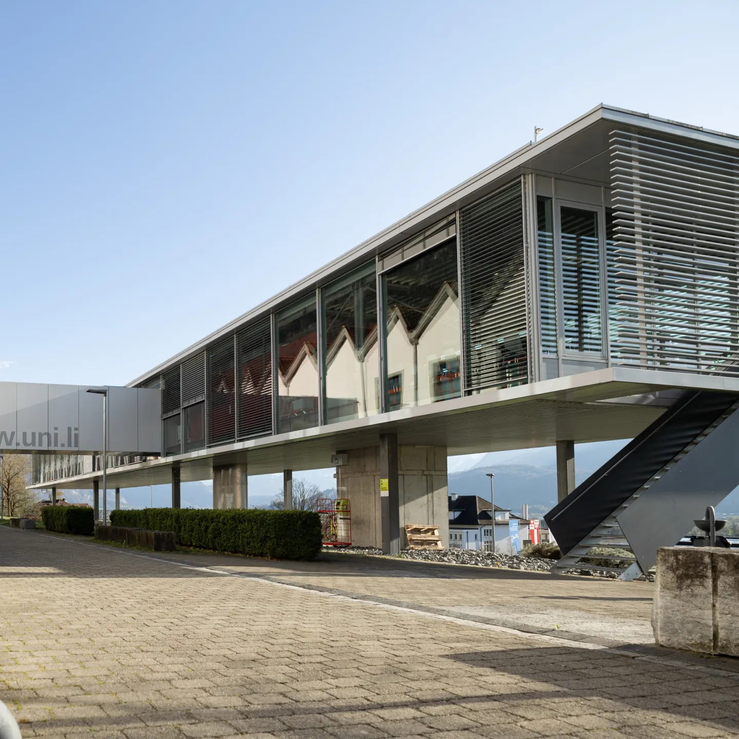 Moderne Architektur mit Glasfassade und Verbindungselementen auf dem Campus der Universität Liechtenstein.