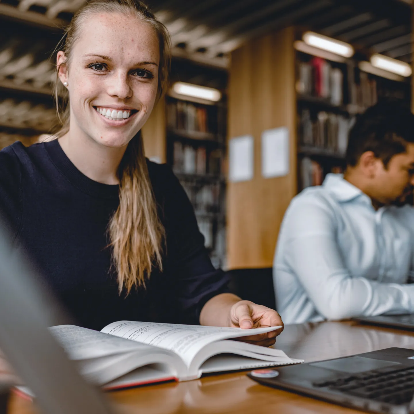 PhD Studierende der Universität Liechtenstein im Bereich Wirtschaftswissenschaften beim wissenschaftlichen Arbeiten in der Bibliothek.