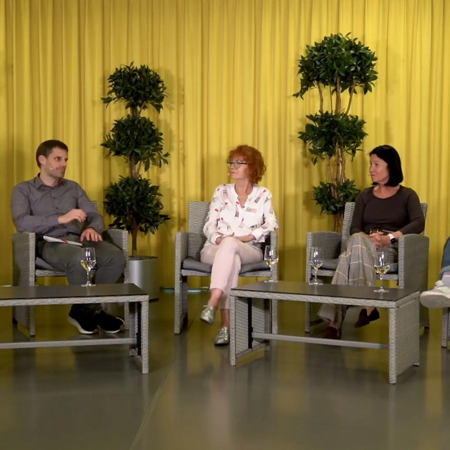 Podiumsdiskussion an der Universität Liechtenstein: Fünf Personen sitzen in einem Studio mit gelbem Vorhang und Pflanzen im Hintergrund. Sie diskutieren über Medienvielfalt und künstliche Intelligenz.
