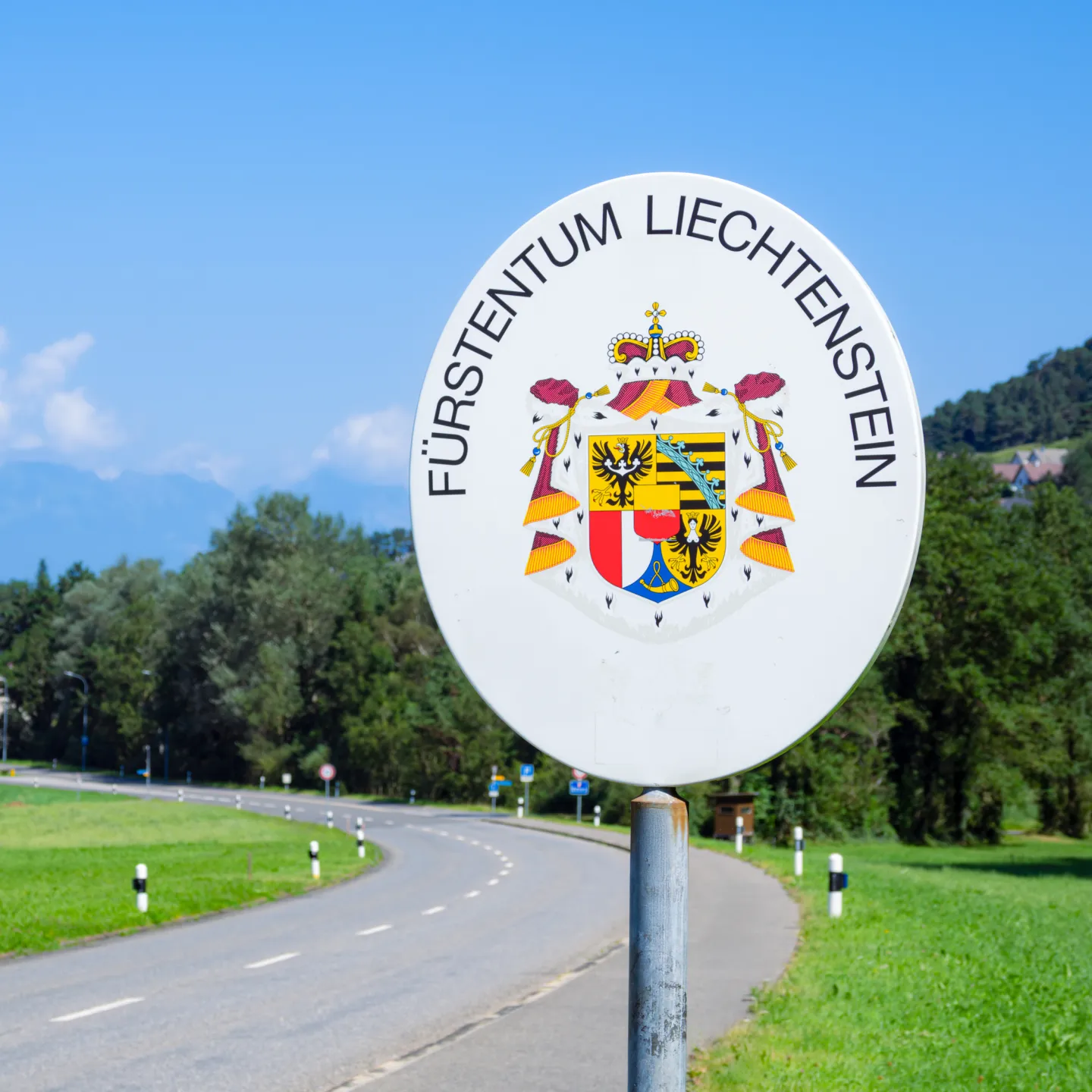 Grenzschild Fuerstentum Liechtenstein Strasse in grüner Umgebung