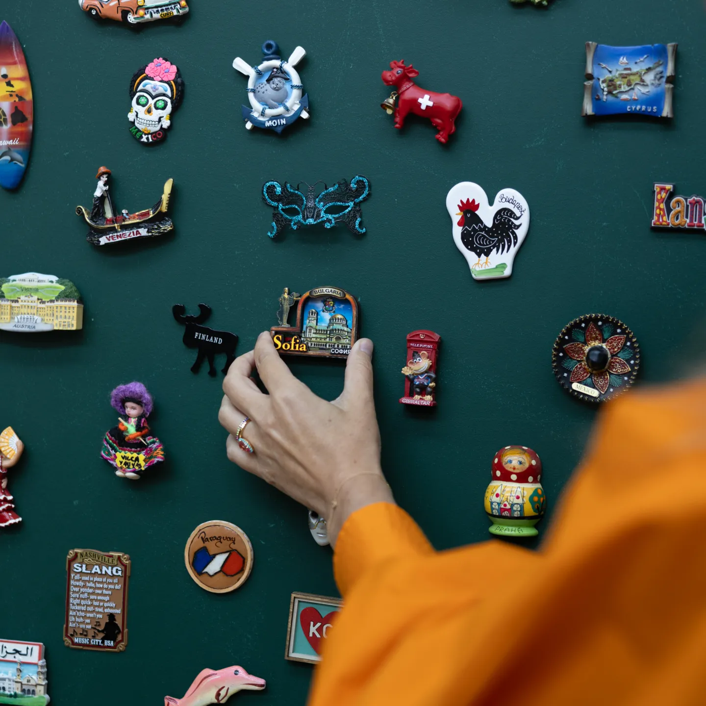 Hand platziert Souvenir-Magnet aus Sofia an Magnetwand.