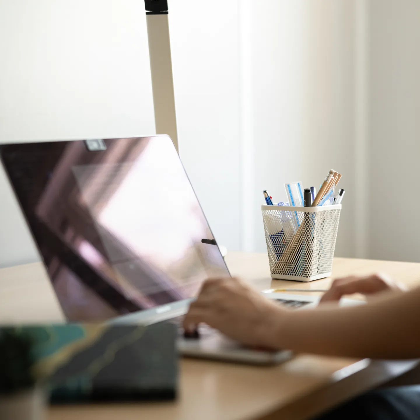 Studierende arbeitet am Laptop am Schreibtisch im Studierendenwohnheim der Universität Liechtenstein.