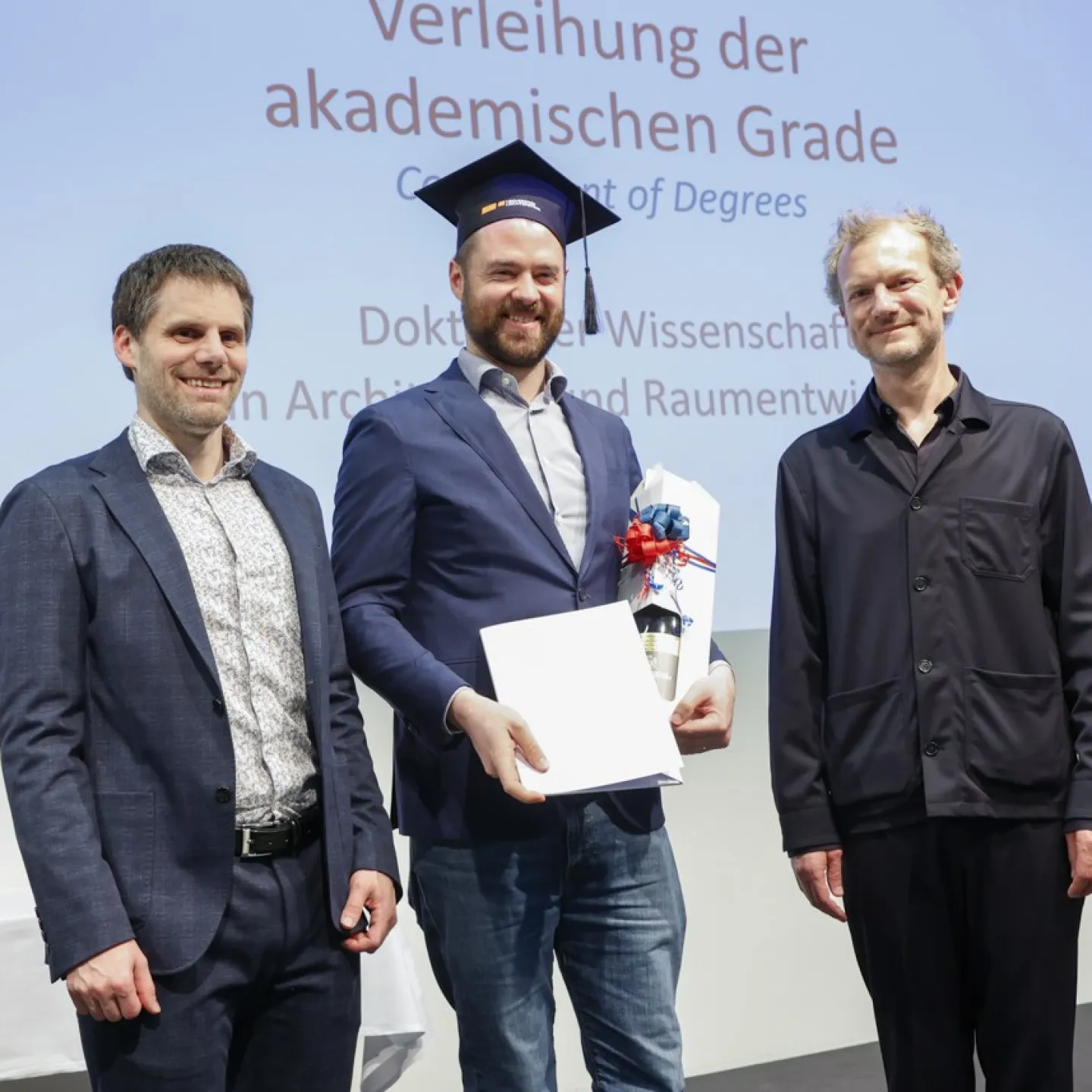 Auf dem Bild sind Dr. Christian Frommelt und Prof. Dipl. Arch. ETH Michael Wagner gemeinsam mit Dr. Luis Gabriel Hilti welcher gerade sein Diplom erhalten hat.