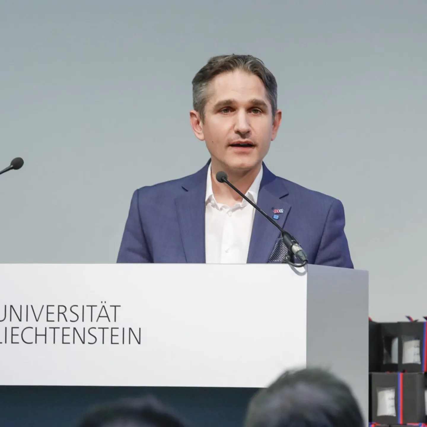 Dr. Thomas Nägele steht vor einem Rednerpult und hält eine Rede.