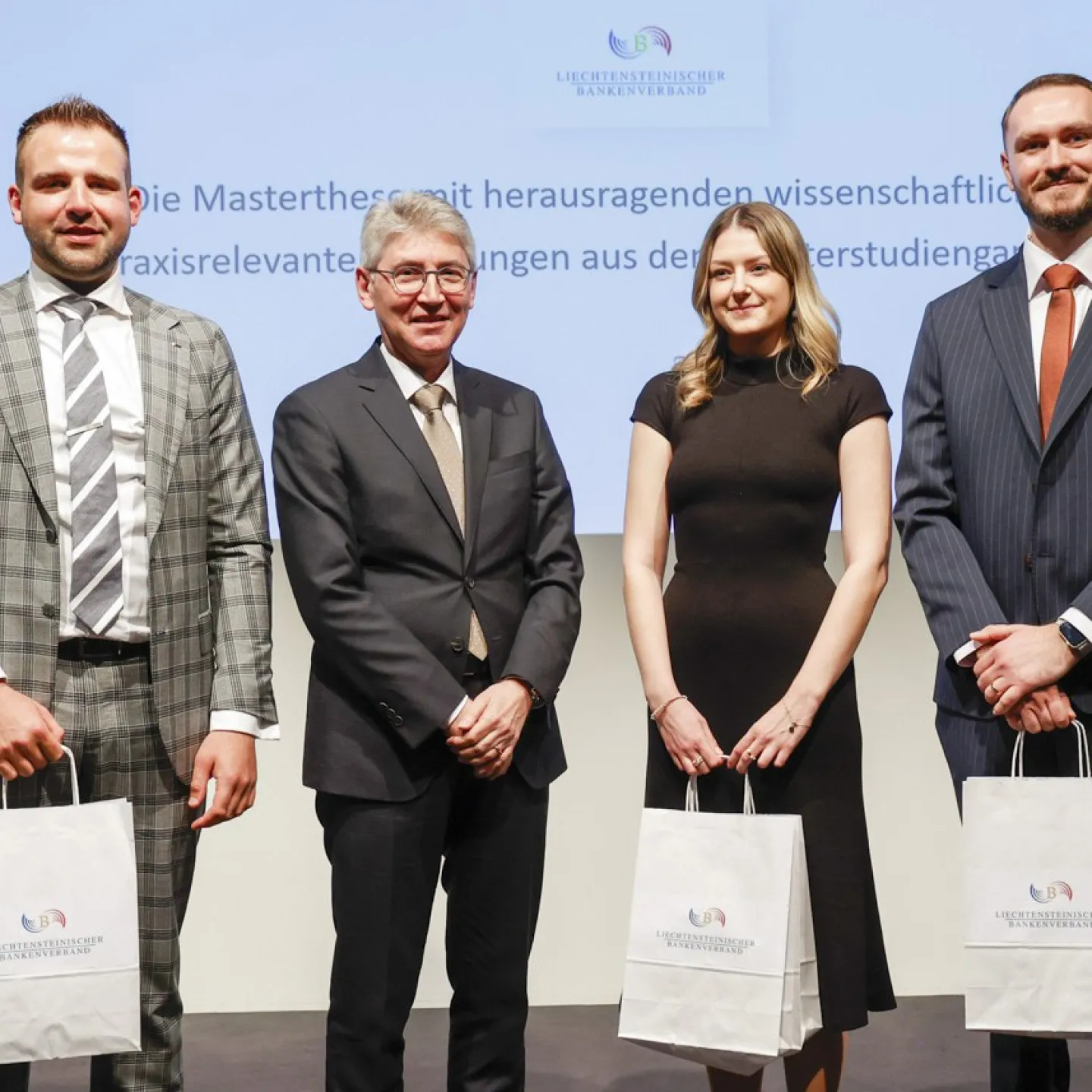 Dr. Hans-Werner Gassner neben Mykola Subtelnyi, Natalie Galli und Ermal Gashi mit einer Tüte in der Hand.