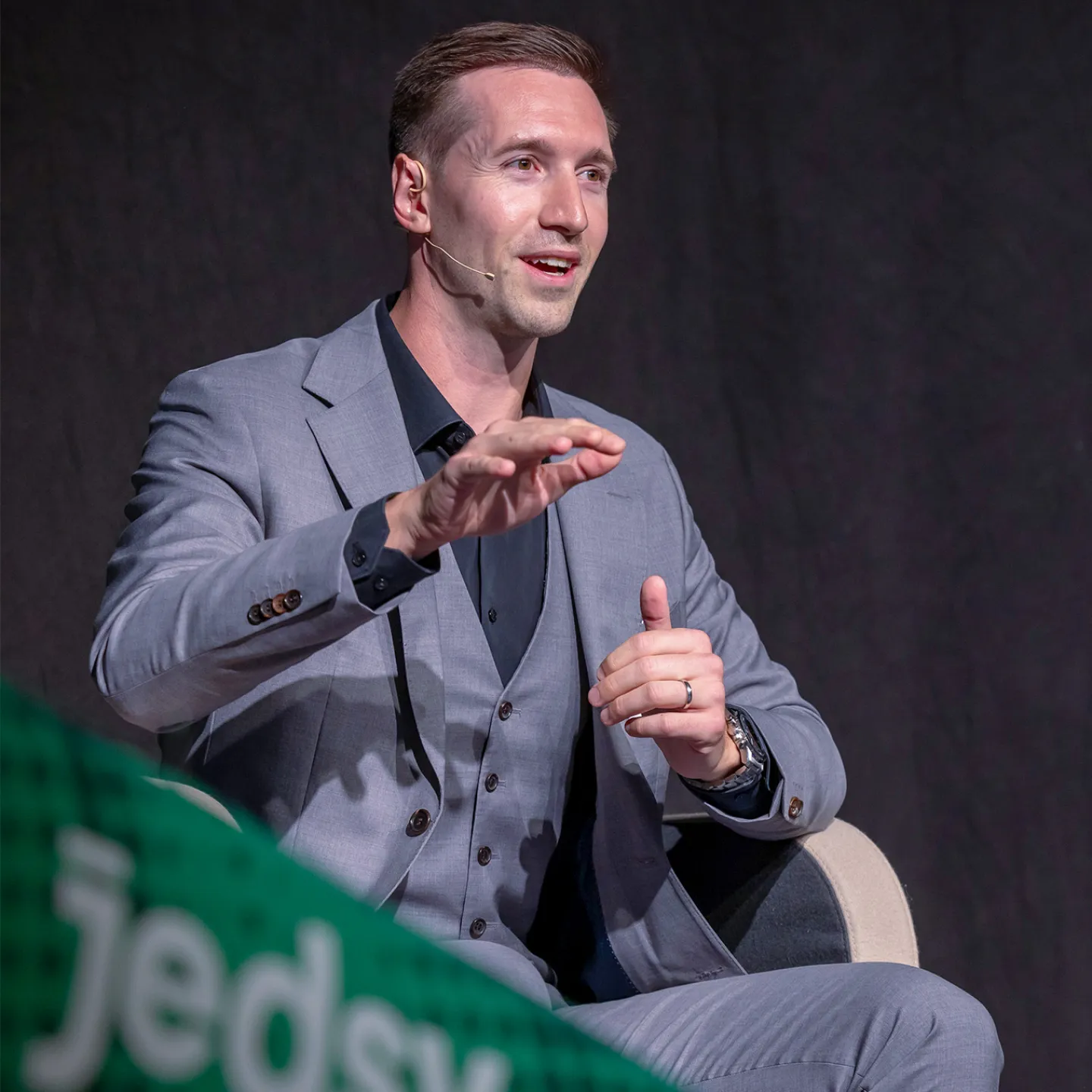 Referenten diskutieren auf Podium bei Wirtschaftskonferenz vor Publikum