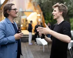 Zwei Männer stehen draußen und unterhalten sich 