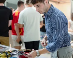 Student steht auf dem Campus der Universität Liechtenstein am Buffet während der Welcome Days