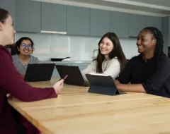Studierende im Wohnheim der Universität Liechtenstein arbeiten gemeinsam an Laptops in der Gemeinschaftsküche.