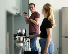 Studierende im Wohnheim der Universität Liechtenstein kochen gemeinsam in der modernen Küche.