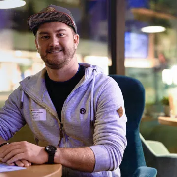 Porträt eines Alumni der Universität Liechtenstein mit Namensschild bei einem Treffen