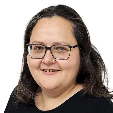 Porträt einer Frau mit Brille und schwarzen Haaren vor weißem Hintergrund an der Universität Liechtenstein.