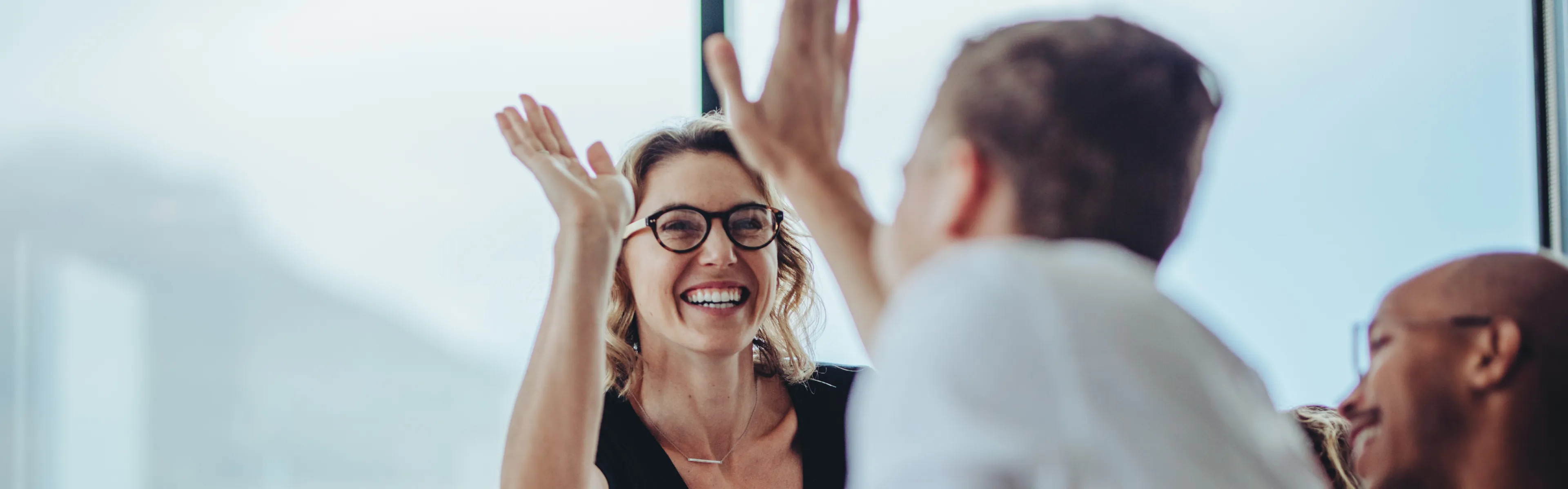 Teilnehmende einer Weiterbildung an der Universität Liechtenstein freuen sich über gemeinsame Erfolge und geben sich ein High-Five.