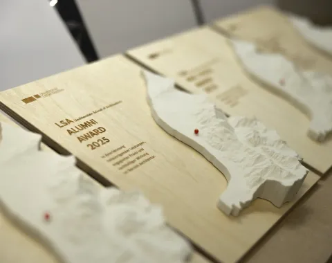 Nahaufnahme von Holztafeln mit 3D-Reliefs und der Aufschrift "LSA Alumni Award 2025". Die Tafeln sind Teil einer Preisverleihung der Liechtenstein School of Architecture.