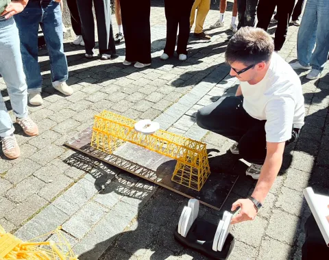 Student baut eine Brücke aus Spaghettinudeln