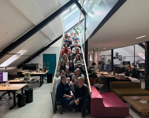 Gruppenbild junger Menschen auf einer Treppe in einem Atelier