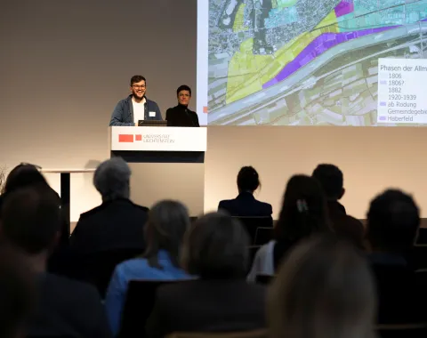 Eine Person präsentiert an einem Vortragspult