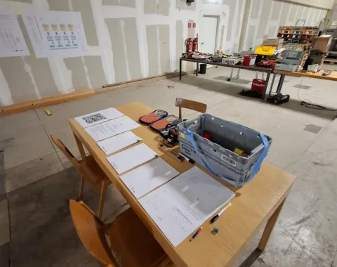 Ein Holzstuhl und Holztisch in einer grossen Halle 