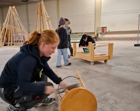 Drei Jugendliche arbeiten handwerklich mit Holz