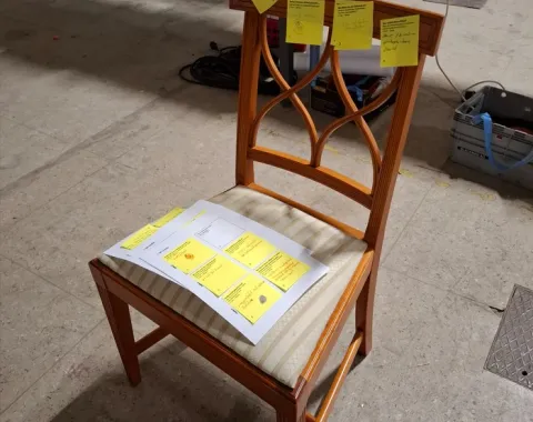 Ein Holzstuhl mit Notizen drauf 