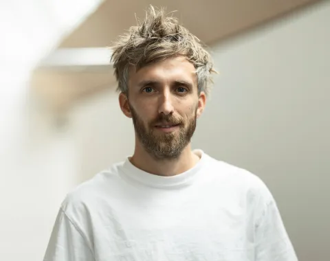 Foto eines jungen Mannes mit weissem T-Shirt und Bart