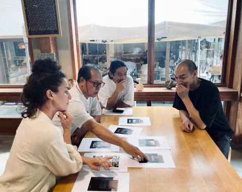 Gruppe analysiert Entwürfe und Bilder bei gemeinsamer Projektarbeit im Arbeitsraum