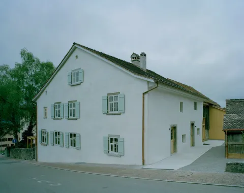 Historisches Wohnhaus in Liechtenstein mit heller Fassade und traditionellen Fensterläden