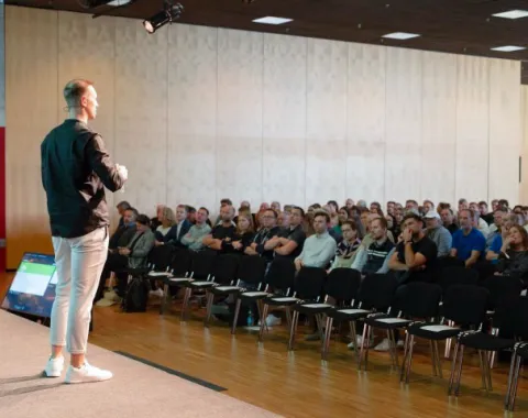 Referent präsentiert vor Publikum im Hörsaal bei Konferenz