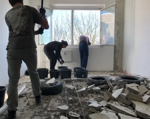 Drei Menschen brechen Wände in einem Raum ab