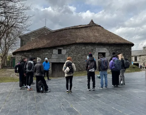 Gruppe von Studierenden schaut auf ein historisches Steingebäude in Portugal