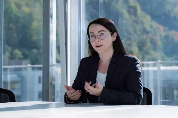 Gesprächsszene mit einer Expertin im Businessoutfit im lichtdurchfluteten Besprechungsraum der Universität Liechtenstein