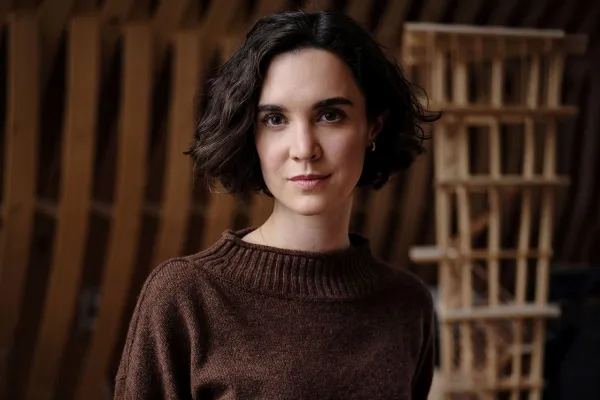 Architektur-Portrait-einer-PhD_Studentin-der-Liechtenstein-School-of-Architecture-mit-Holzmodellen-im-Hintergrund