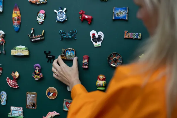 Hand platziert Souvenir-Magnet aus Sofia an Magnetwand.