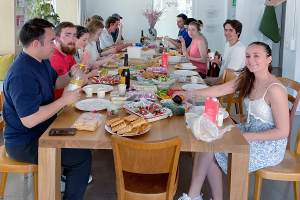 Internationale Studierende sitzen um einen Tisch beim Essen
