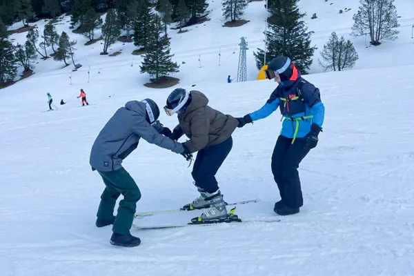 Studierende beim Skifahren mit Skilehrer